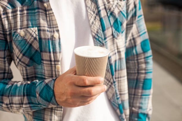 istock Paper cup of coffee in man hand 1183737871