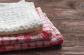 kitchen towels are stacked against a wood background with a copy of the space