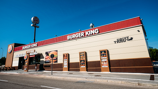 Madrid, Spain - Oct 26, 2019: Outside a fast-food Burger King restaurant with a sleek, contemporary futuristic industrial look includes brick cladding and drive-thru order point