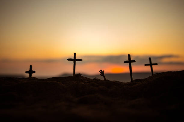 istock Silhouette some zombies on the cemetery walking around at sunset. Selective focus 1183745306