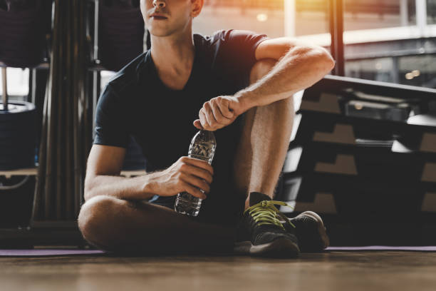 istock muscular caucasian young handsome man taking a break relax and drinking water while resting after workout for good healthy in fitness gym at morning, bodybuilder, lifestyle and sport exercise concept 1183746031