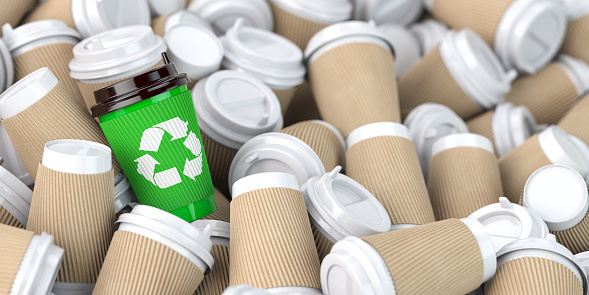 Señal de reciclaje en uno de los montones de muchas tazas de café de papel vacías. photo