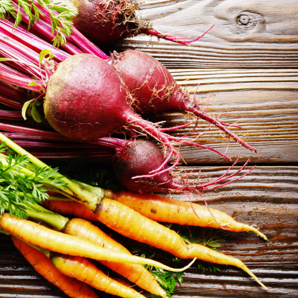 istock Fresh organic beetroots and carrots on kitchen wooden rustic table close up view 1183747399