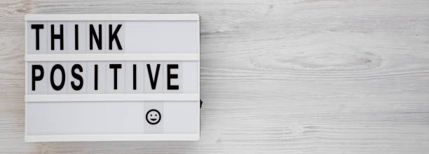 istock 'Think positive' words on a lightbox on a white wooden surface, top view. Overhead, from above, flat lay. Copy space. 1183748274