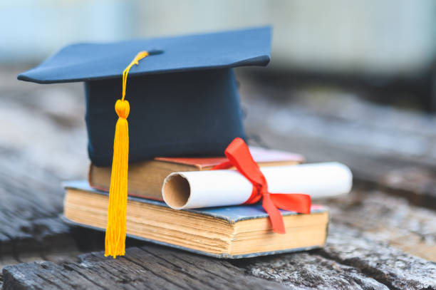 istock Black graduates hat and yellow tassel place an old book 1183749366