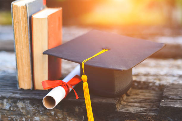 istock Black graduates hat and yellow tassel place an old book 1183749377