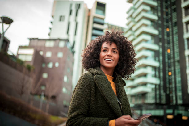 eine lächelnde junge frau in der innenstadt - business women people portrait stock-fotos und bilder