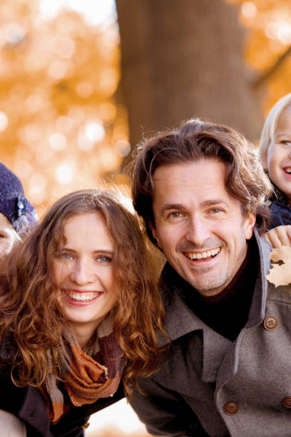 istock Family hug in autumn park 1183750545