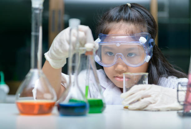 istock Little girl wearing safty goggle making experiment 1183753713
