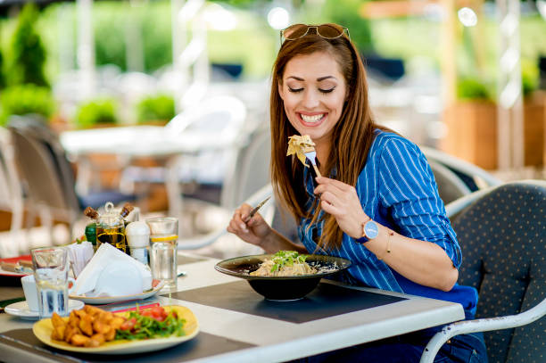 istock Young girl is eating pasta in the restaurant 1183754703