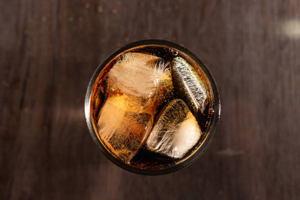 istock Cola and ice in a clear glass on wood table 1183759537