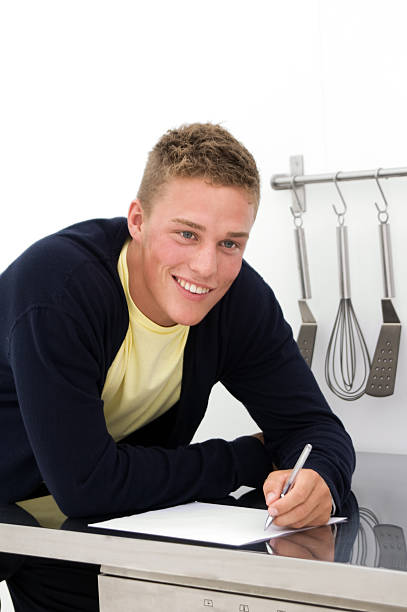 Jovem escrevendo para baixo a receita - fotografia de stock