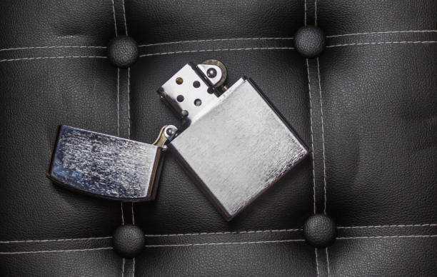 istock Chrome zippo gasoline lighter on black leather with seams 1183760503