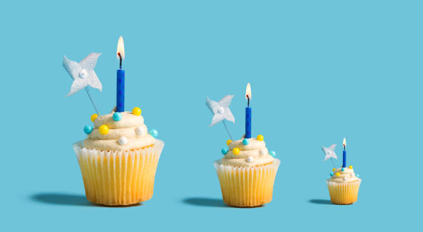 istock Big and small cupcakes with lit candles 1183761517