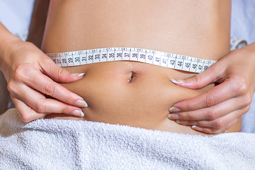 taking measures of woman's waist before weight loss treatment