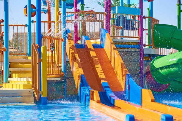 Colorful slides in waterpark close up. Aquapark sliders with pool