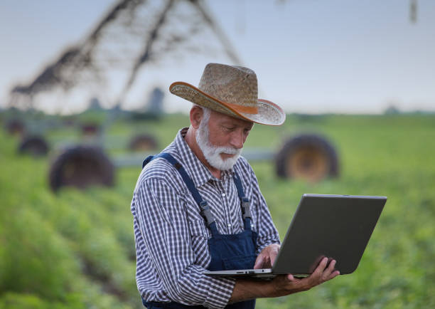 istock Farmer with laptop in front of irrigation system in field 1183764519