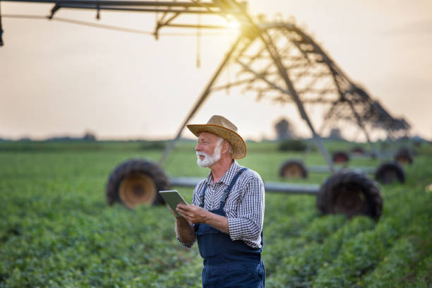 istock Farmer with tablet in front of irrigation system in field 1183764542