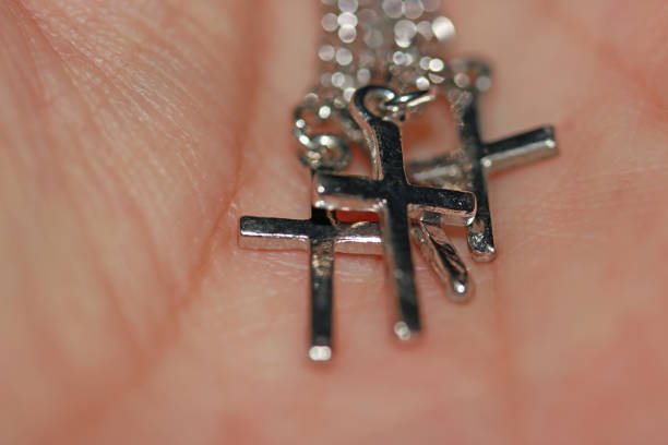 Metal crucifix bracelet on the palms. concept of faith and belief.