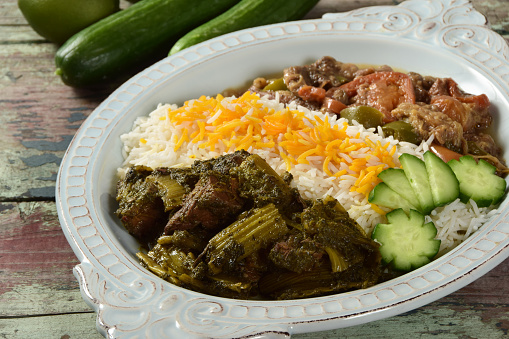 Traditional Persian, Iranian, stews - Khoresh Karafs (celery and beef) and Khoresh Bademjan (eggplant) served with rice and Persian cucumbers.