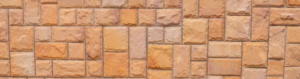 istock Orange grunge stone wall texture background for exterior decoration. 1183767211