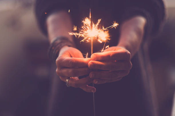 concepto de vida nocturna de fiesta y noche de año nuevo 2020 - primer plano de las manos de la gente con chispas de fuego rojo para celebrar la noche y el nuevo comienzo - filtro de colores cálidos - sparkler fotografías e imágenes de stock