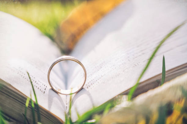 istock Golden engagement ring and old book. Background for a romantic wedding card 1183770933