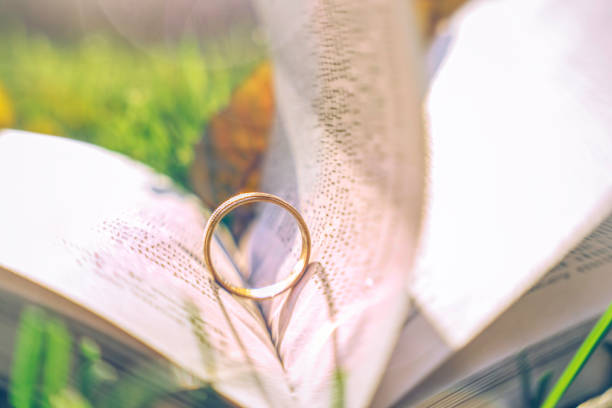 istock Golden engagement ring and old book. Background for a romantic wedding card 1183770943