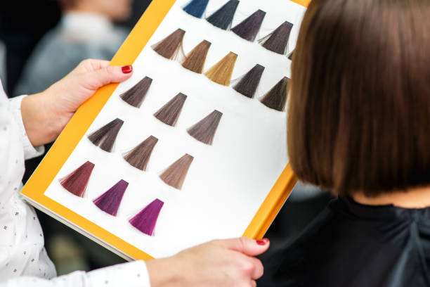 istock Women hands with a dye color catalog. 1183774254