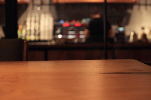 Empty wooden table top with blur coffee shop or restaurant interior background,