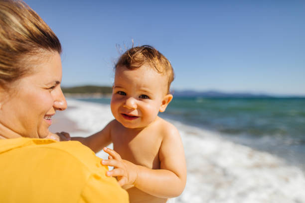 istock Baby boy with mommy at the beach 1183776805