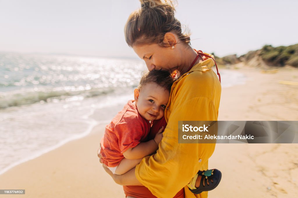 Hug for my baby boy Photo of mother hugging her baby boy while enjoying together at the beach Baby - Human Age Stock Photo