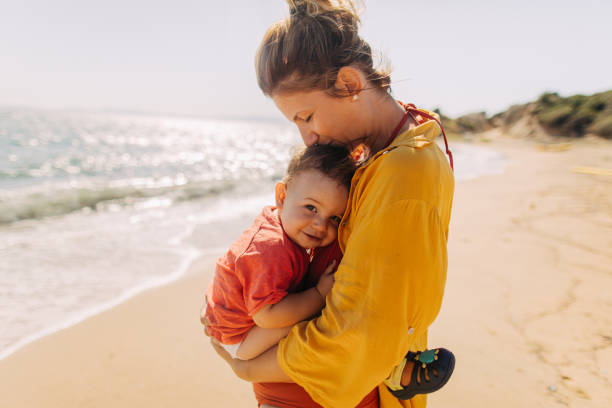 Hug for my baby boy Photo of mother hugging her baby boy while enjoying together at the beach baby boys photos stock pictures, royalty-free photos & images