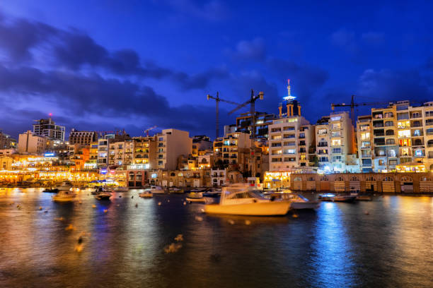 Paceville in St Julian Town at Night in Malta Paceville skyline in St. Julian town at night in Malta, apartment buildings along Spinola Bay st julians bay stock pictures, royalty-free photos & images