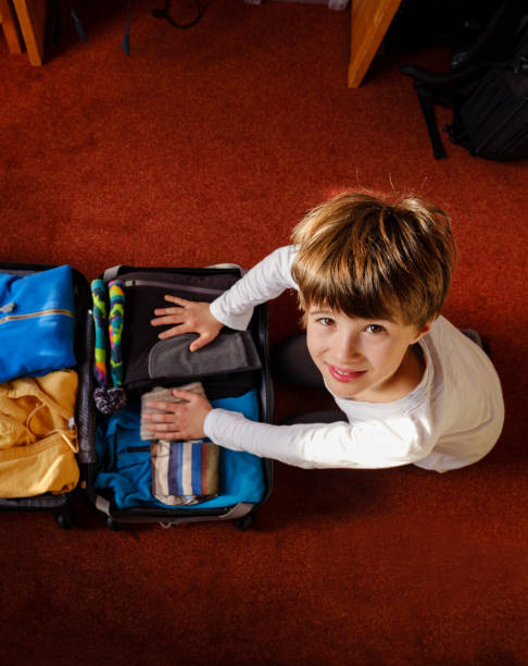 istock The child prepares the suitcase 1183779290