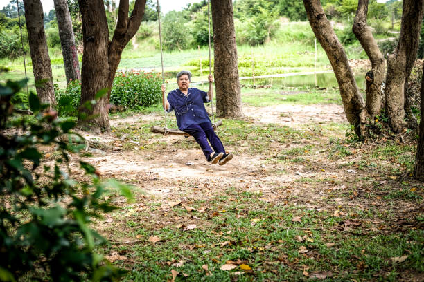 istock old mature elderly senior woman sitting on swing 1183780416
