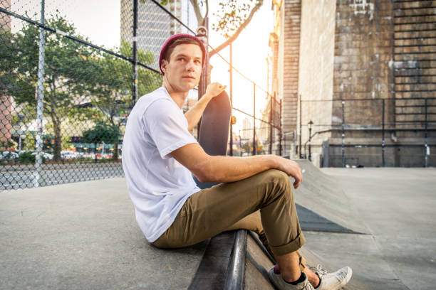 Young adult skating outdoors - Stylish skater boy training in a nNew York skate park, concepts about sport and ifestyle