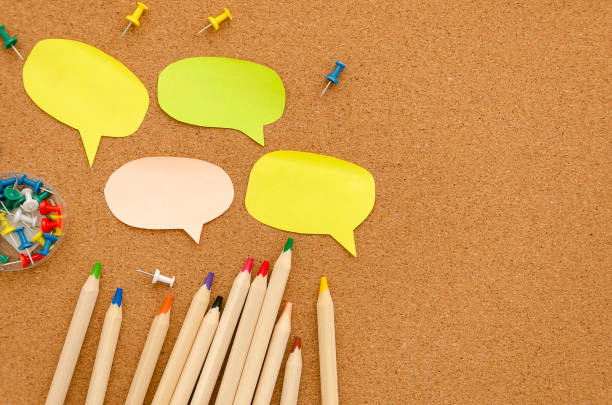 istock Flat lay mockup cork desk with pencils, pins and sticky notes with shape chat balloons with copy space. Back to school concept 1183782447