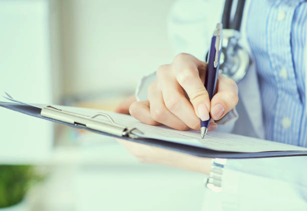 istock Professional physician's hands writing something in notepad. Smart doc standing in clinic office. Medical treatment and healthcare concept. 1183783519