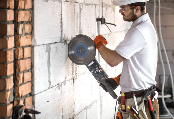 istock The industrial Builder works with a professional angle grinder to cut bricks and build interior walls. Electrician. 1183783586