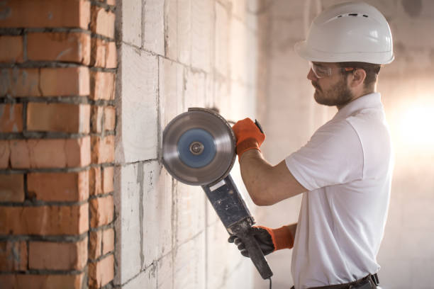 istock The industrial Builder works with a professional angle grinder to cut bricks and build interior walls. Electrician. 1183783598