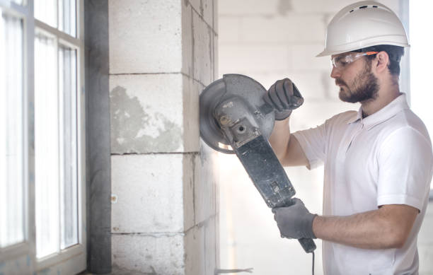 istock The industrial Builder works with a professional angle grinder to cut bricks and build interior walls. Electrician. 1183783600