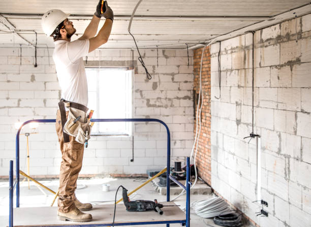 istock Electrician installer with a tool in his hands, working with cable on the construction site. 1183783605