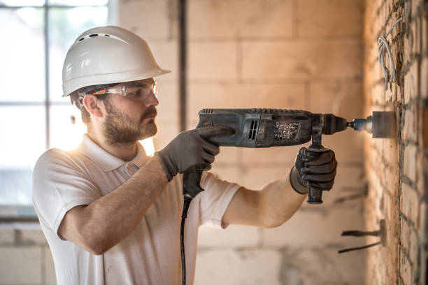 istock Handyman uses jackhammer, for installation, professional worker on the construction site. The concept of electrician and handyman. 1183783614