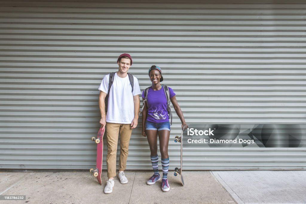Skaters training in a skate park in New York Young adults skating outdoors - Stylish skater boy and girl training in a New York skate park, concepts about sport and ifestyle African-American Ethnicity Stock Photo