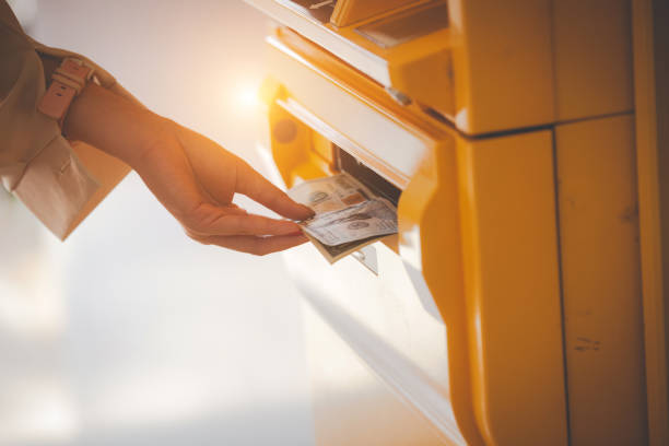 istock hand taking dollar bills out of an ATM 1183786511
