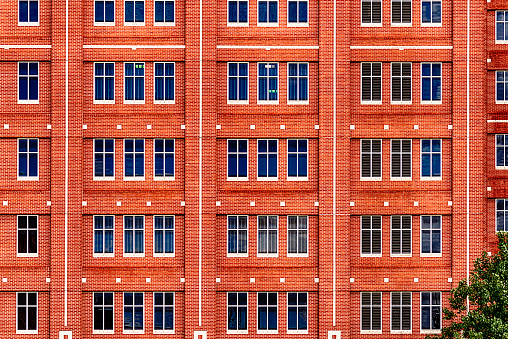 The rows of windows along the side of a large brick building in downtown Houston Texas.
