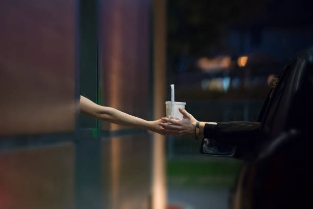 Customer Receiving Drinks at Drive Thru Restaurant Customer Receiving Drinks at Drive Thru Restaurant. fast food restaurant stock pictures, royalty-free photos & images