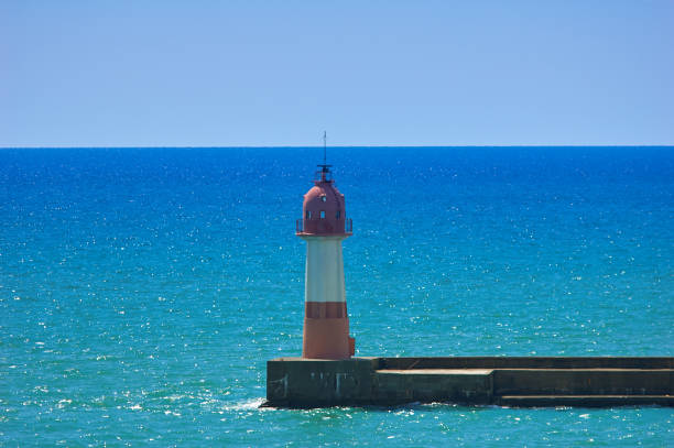 istock lighthouse in the sea at clear sunny day 1183797707
