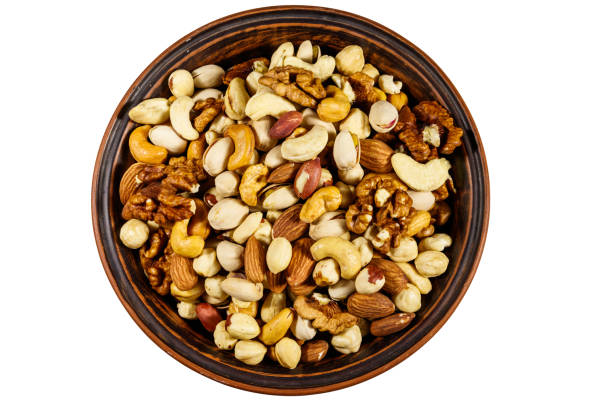 istock Bowl with mixed nuts isolated on white background. Walnuts, pistachio, almond, peanut, cashew, hazelnut in ceramic bowl. Top view 1183797723
